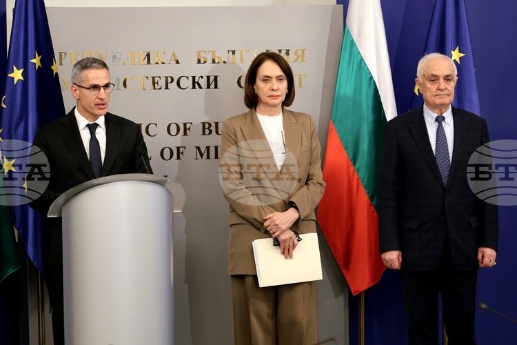 Премьер-министр Болгарии выступает на правительственной пресс-конференции вместе с министрами, на фоне флагов Болгарии и ЕС