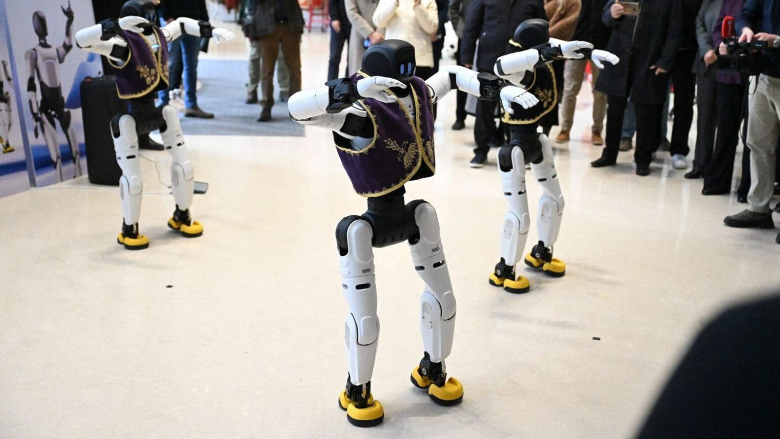 Гуманоидные роботы в традиционных сербских жилетках исполняют синхронный танец на презентации