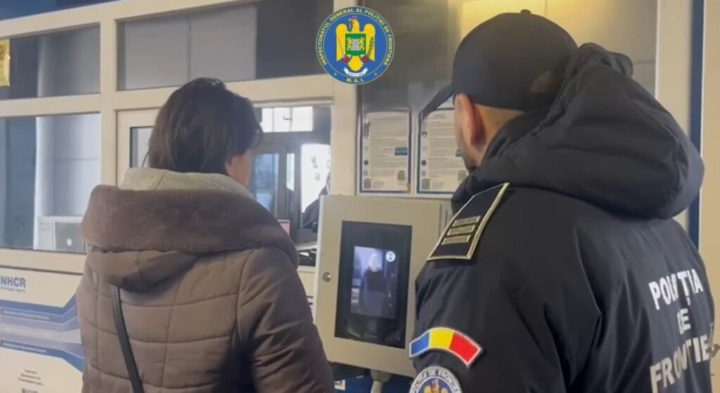 Сотрудник пограничной полиции Румынии помогает путешественнику у биометрического терминала EES на пограничном пункте