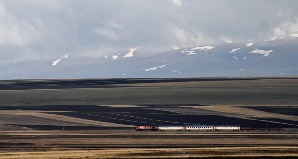 Поезд пересекает армянское нагорье на фоне заснеженных гор