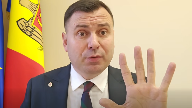 Директор АГУ Вадим Костюк с жестом «стоп» на фоне молдавского флага