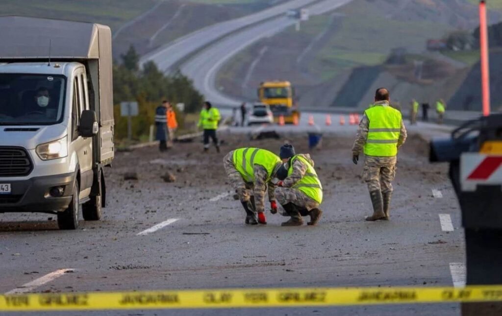 Турецкий F-16 разбился на пути к болгарской границе Военнослужащие в светоотражающих жилетах исследуют место крушения, собирают обломки на дороге, на переднем плане полицейская лента