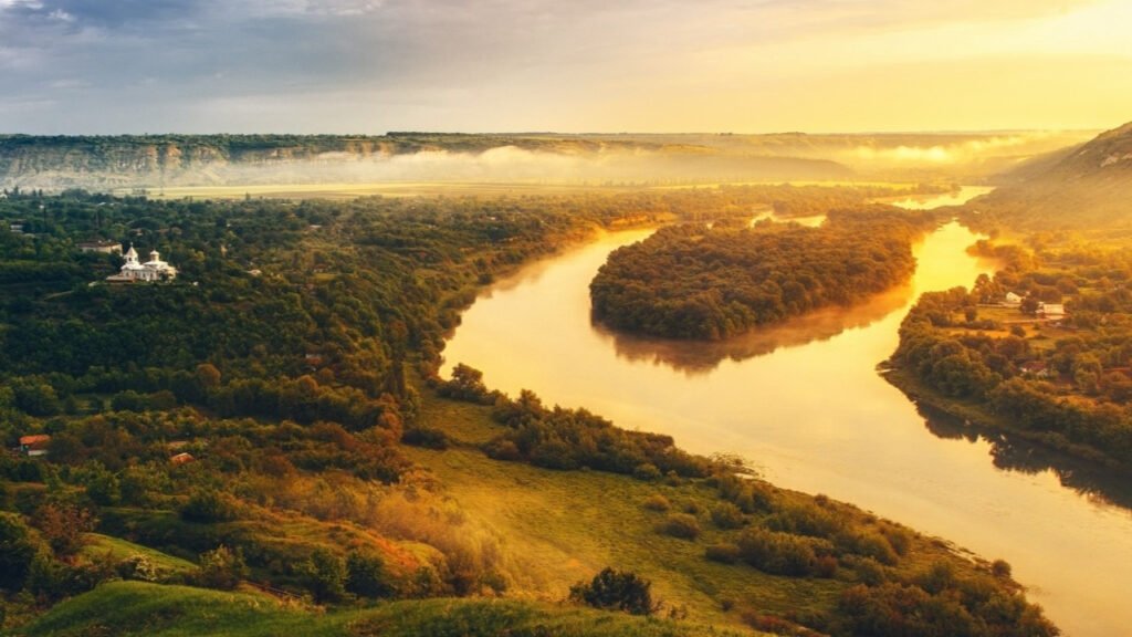 Рекордный год туризма в Молдове: Кишинёв собирает 68%, регионы ждут своей очереди Вид сверху на реку Днестр, петляющую по молдавской сельской местности на закате, с православным монастырём на левом берегу