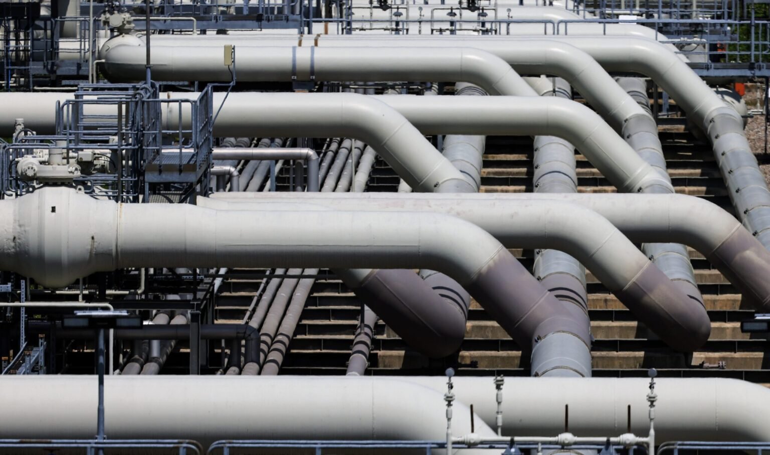 Газопроводная инфраструктура — множество крупных серых труб на промышленном объекте