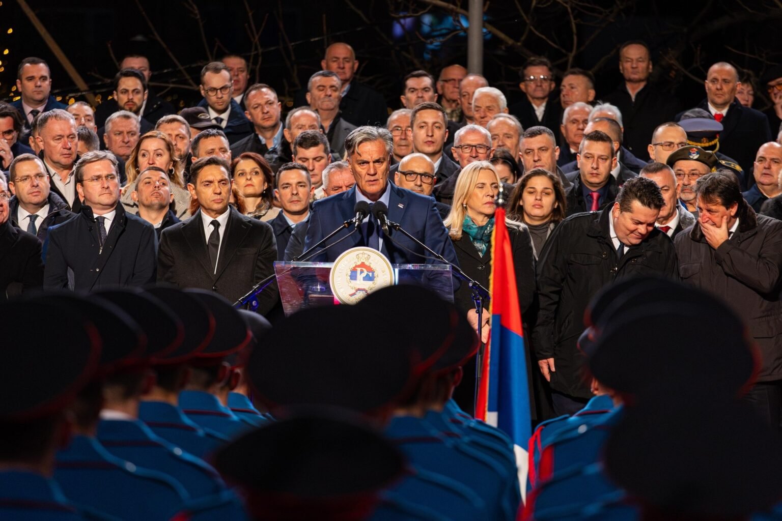 Республика Сербская: новый президент под тенью старого лидера Синиша Каран на церемонии инаугурации, выступает на трибуне в окружении чиновников и почётного караула