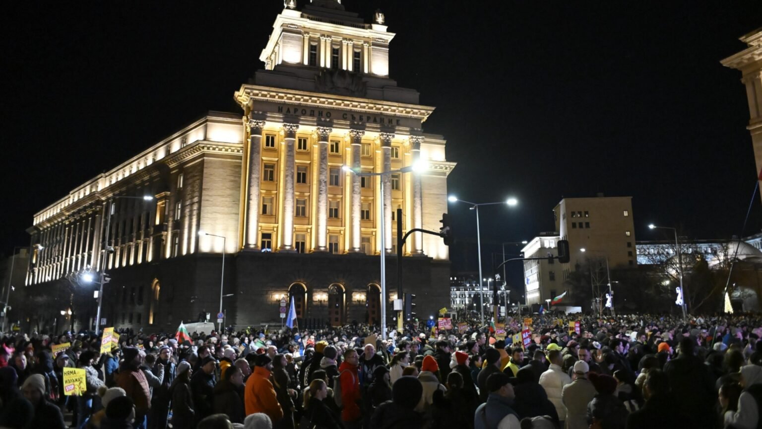 Ночной протест перед зданием Народного собрания в Софии, большая толпа с болгарскими флагами и плакатами