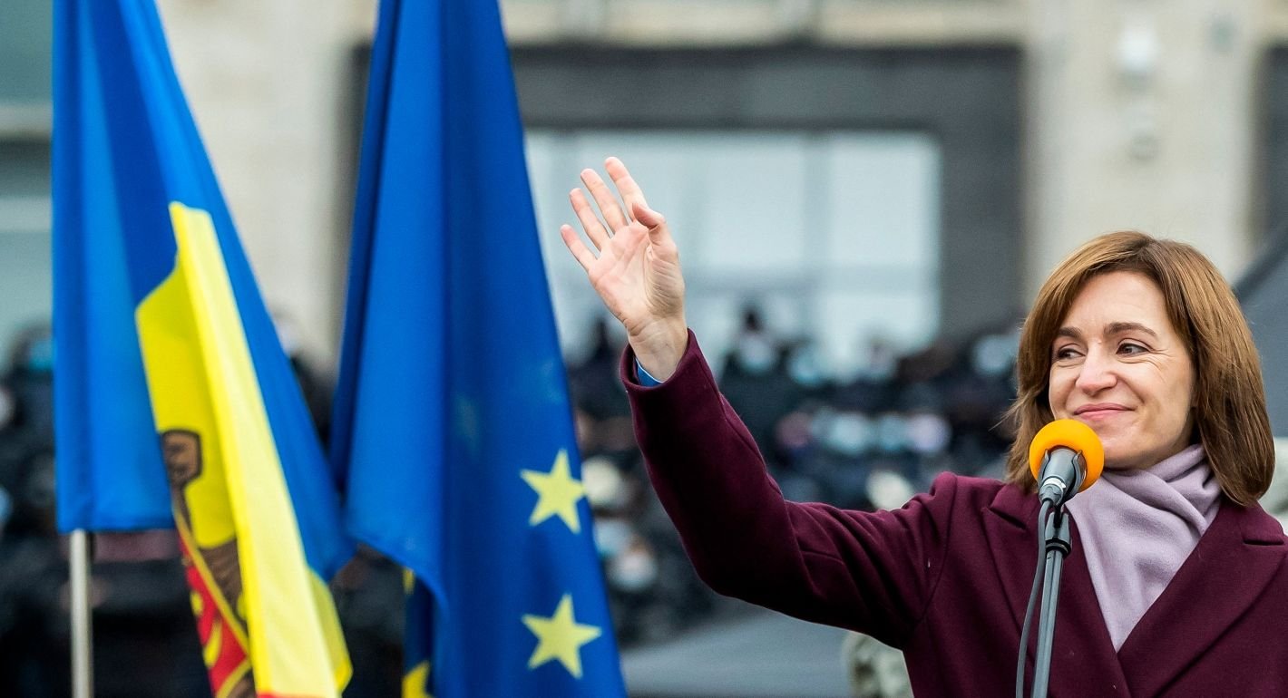 Майя Санду приветствует толпу на фоне флагов Молдовы и ЕС