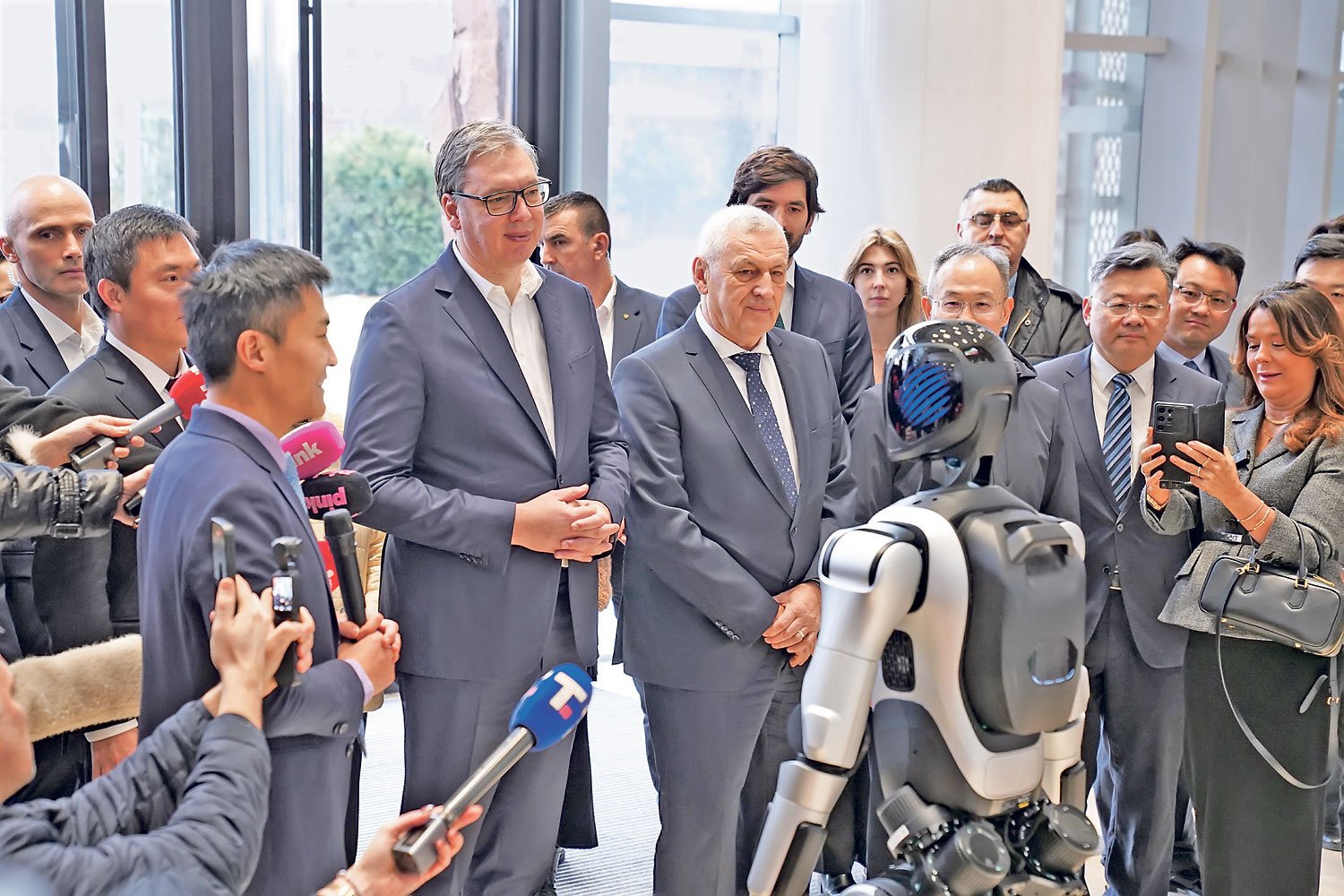 Президент Сербии Александр Вучич с официальными лицами осматривает гуманоидного робота AgiBot на презентации