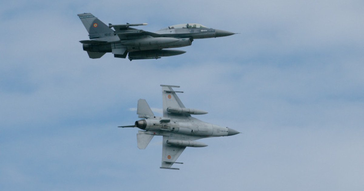 Two Romanian Air Force F-16s flying in formation against cloudy sky