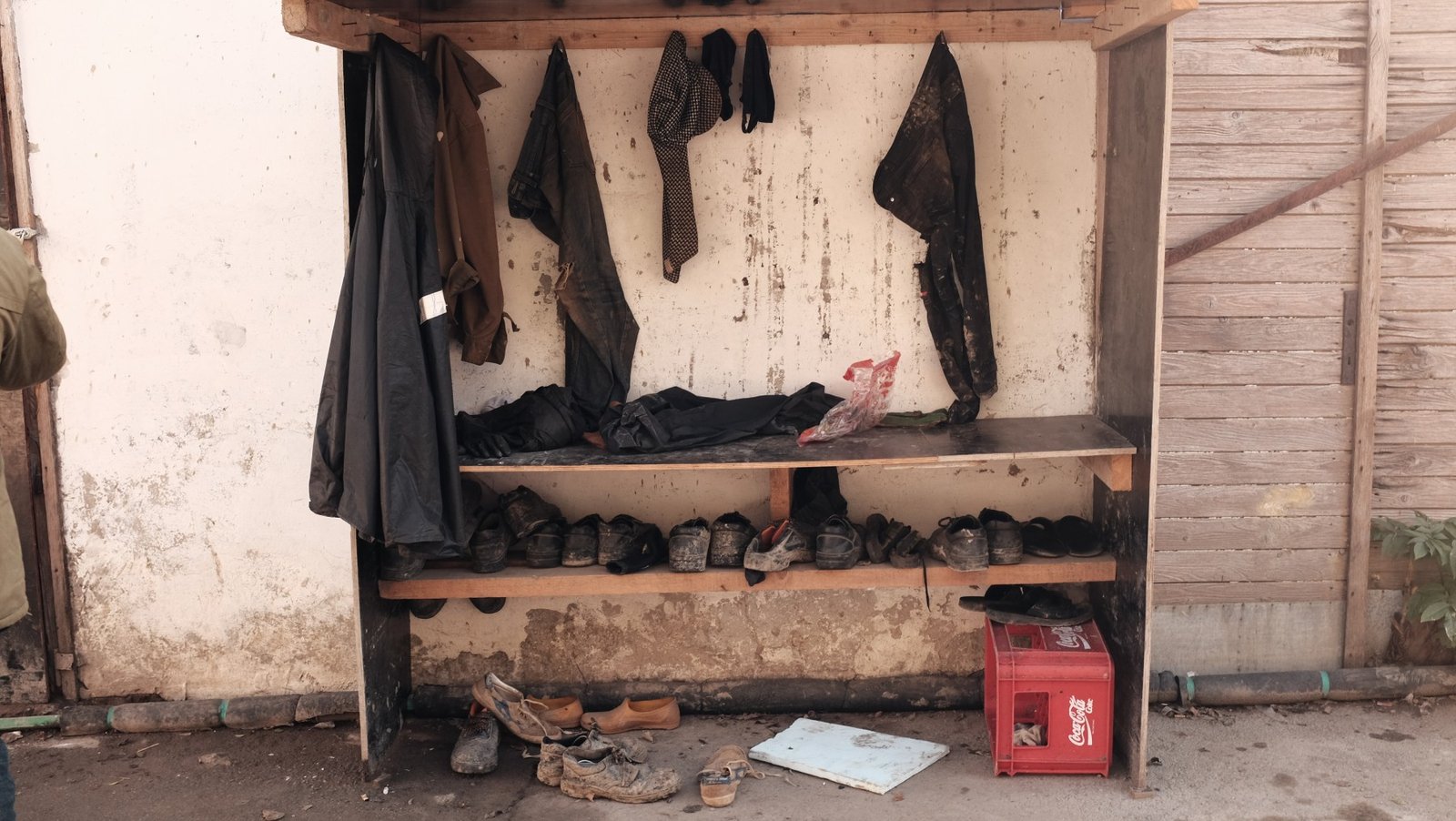 Обувь и одежда рабочих на самодельной вешалке на территории завода — свидетельство тяжёлых условий труда