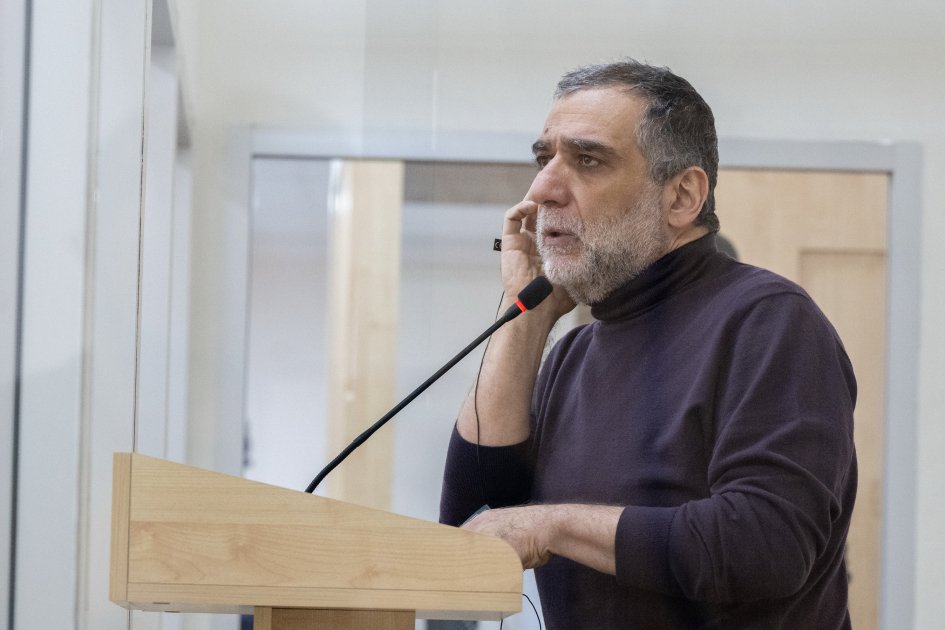 Мужчина выступает на трибуне в зале суда