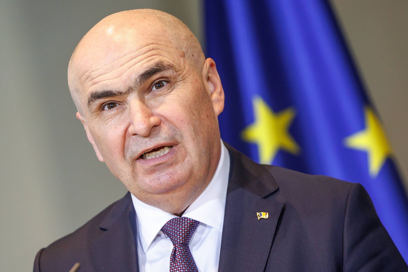 Илие Боложан, премьер-министр Румынии, выступает на фоне флага ЕС