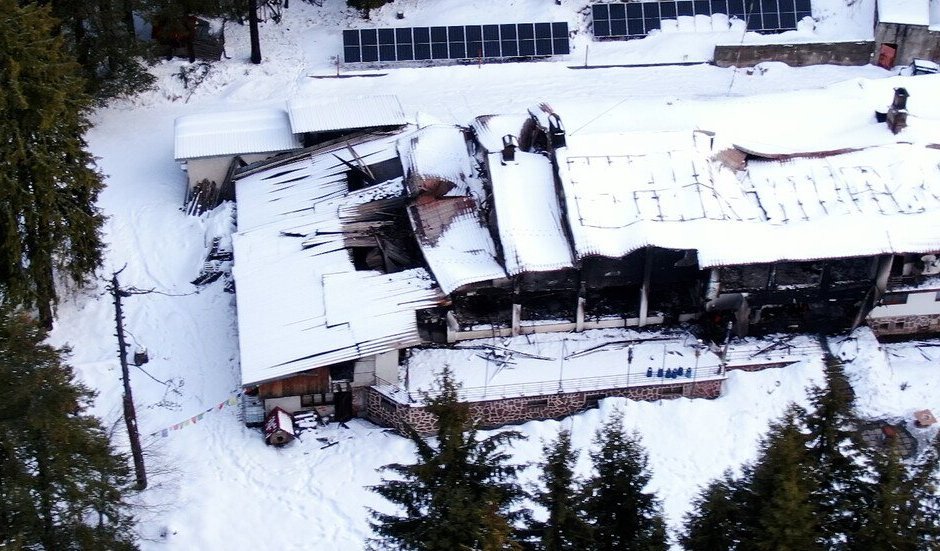 Aerial view of burned/damaged building in snowy mountainous area