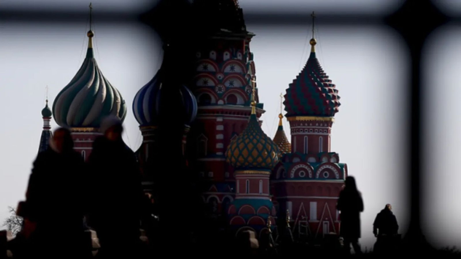 Собор Василия Блаженного сквозь оконную решётку, силуэты прохожих