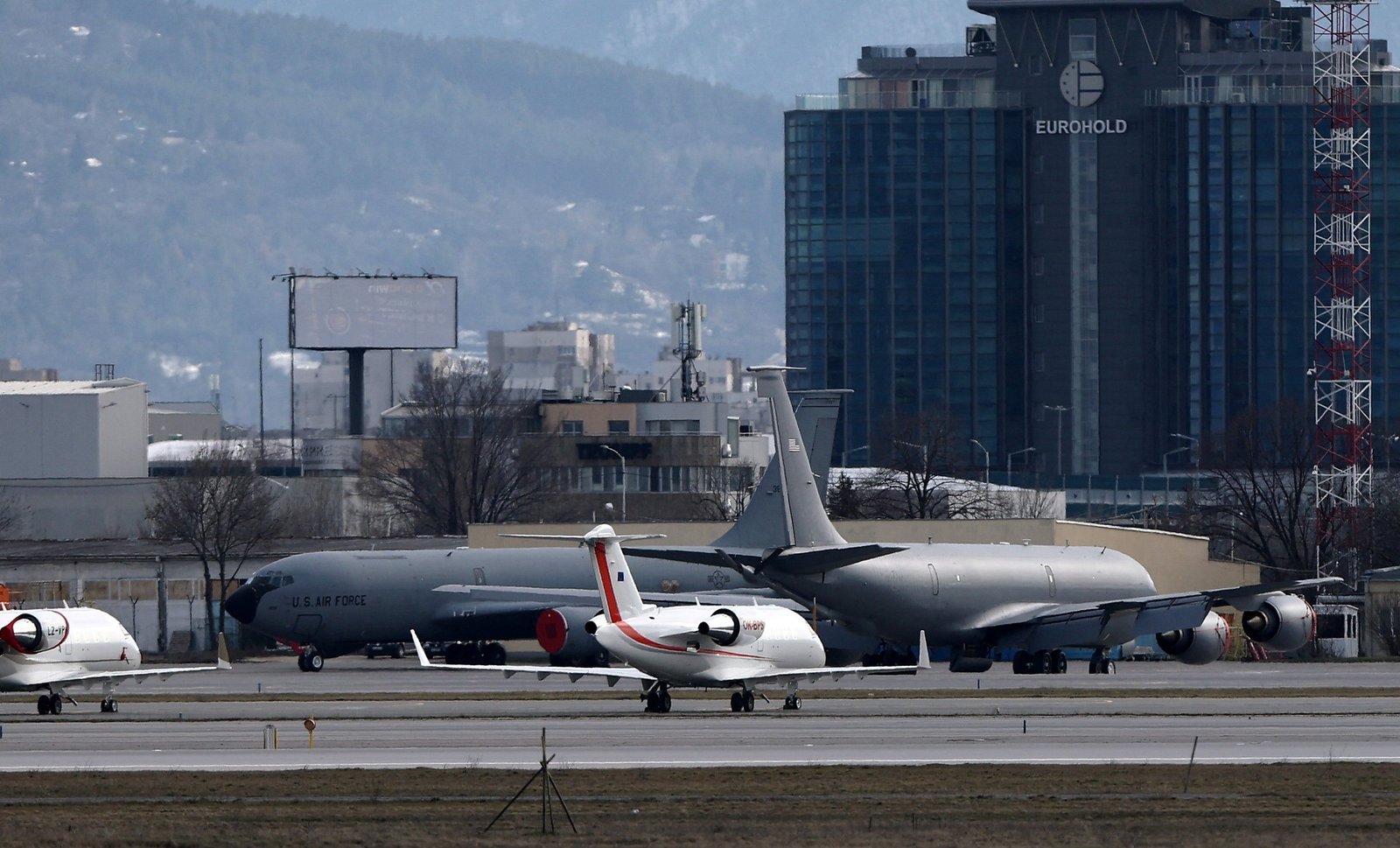 US Air Force aircraft at Sofia Airport with EUROHOLD building visible, showing American military presence in Bulgaria