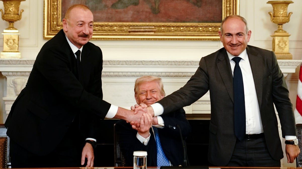 Three-way handshake at diplomatic meeting, showing Aliyev's international relations