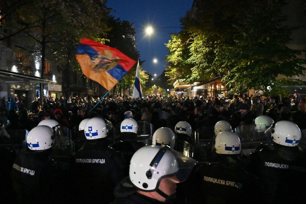 Сербский националистический протест с полицейской бригадой в шлемах напротив толпы с сербским флагом