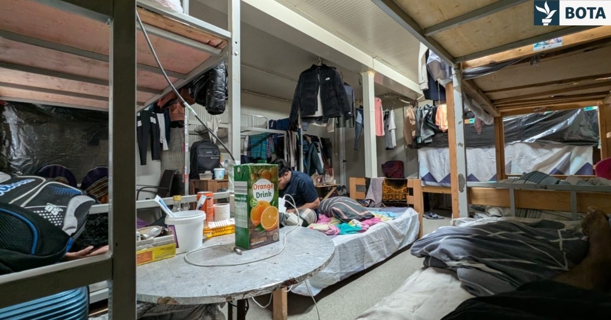 Тесное общежитие рабочих на территории завода Linglong с двухъярусными кроватями и личными вещами