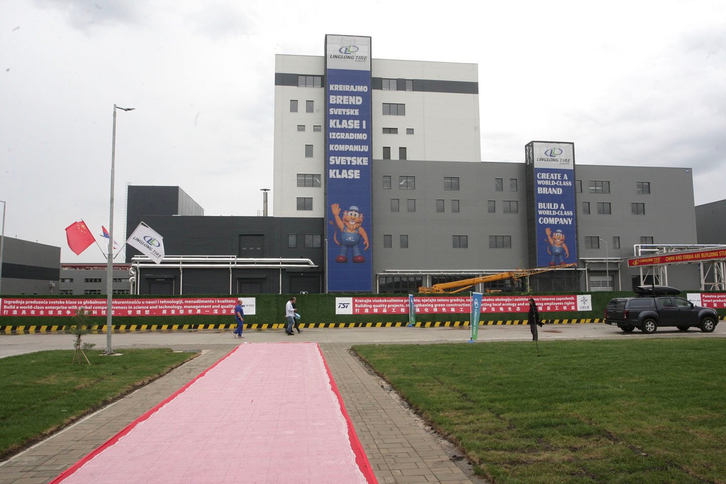 Здание завода Linglong Tire с рекламными баннерами на сербском и английском языках