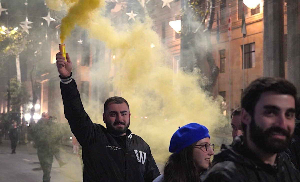 Молодые протестующие с жёлтой дымовой шашкой на ночной демонстрации