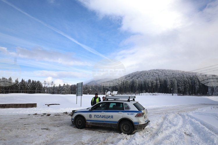 Полицейский внедорожник на перевале Петрохан на фоне заснеженных гор и голубого неба