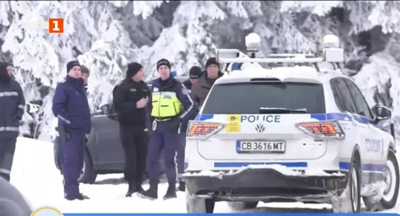 Police officers gathered at snowy scene with police vehicles