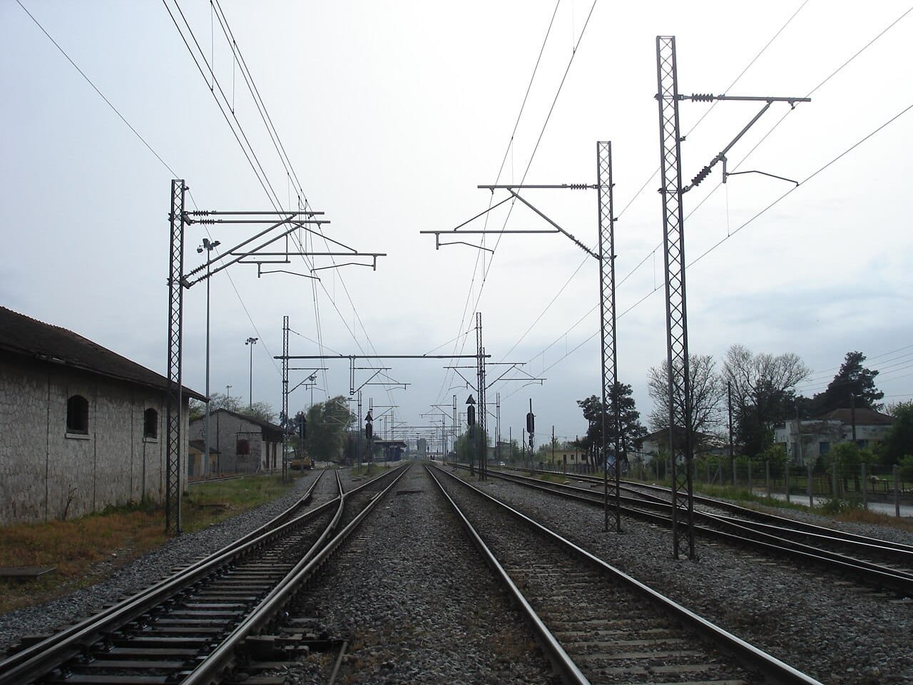 Railway infrastructure in Greece - electrified tracks stretching into distance, representing transport connectivity