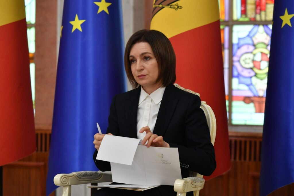 Майя Санду в официальной обстановке на фоне флагов ЕС и Молдовы