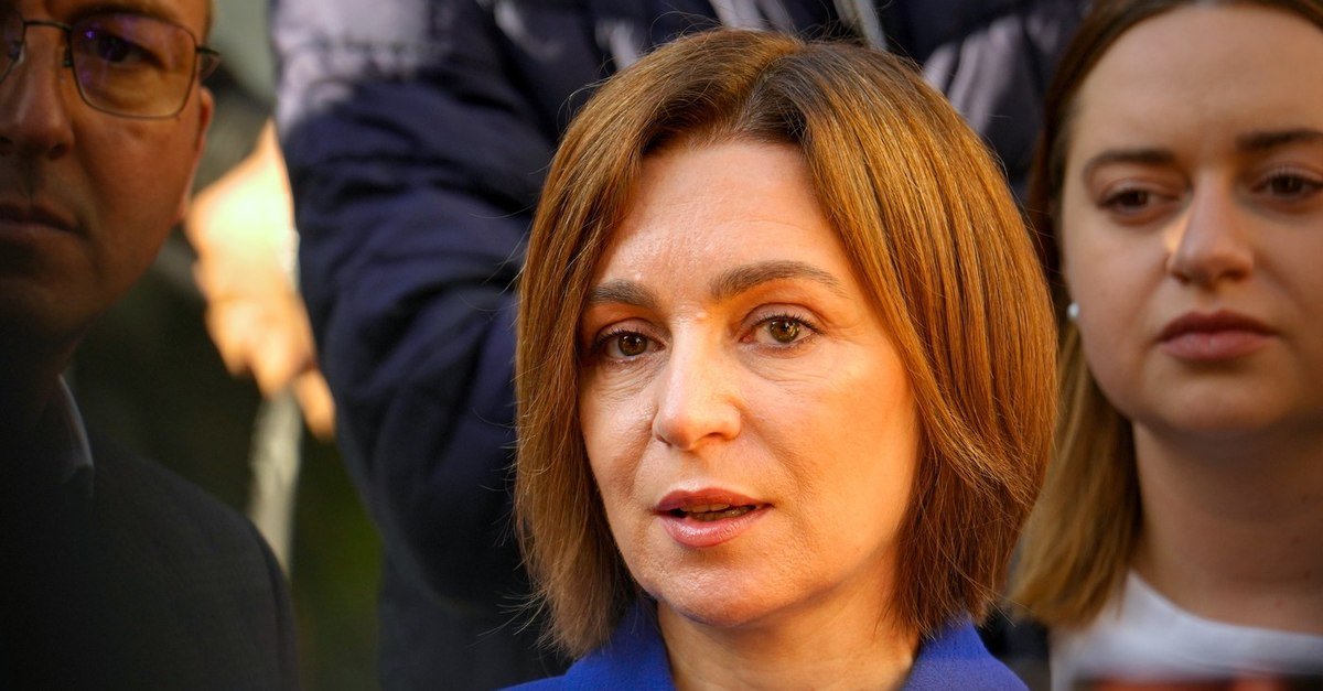 Maia Sandu speaking to press outdoors, blue jacket, surrounded by people