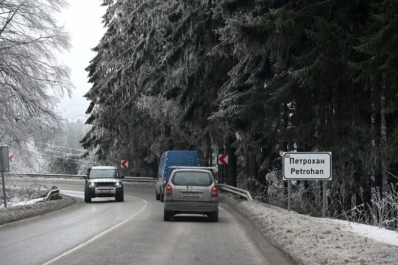 Road to Petrohan with bilingual road sign in winter conditions