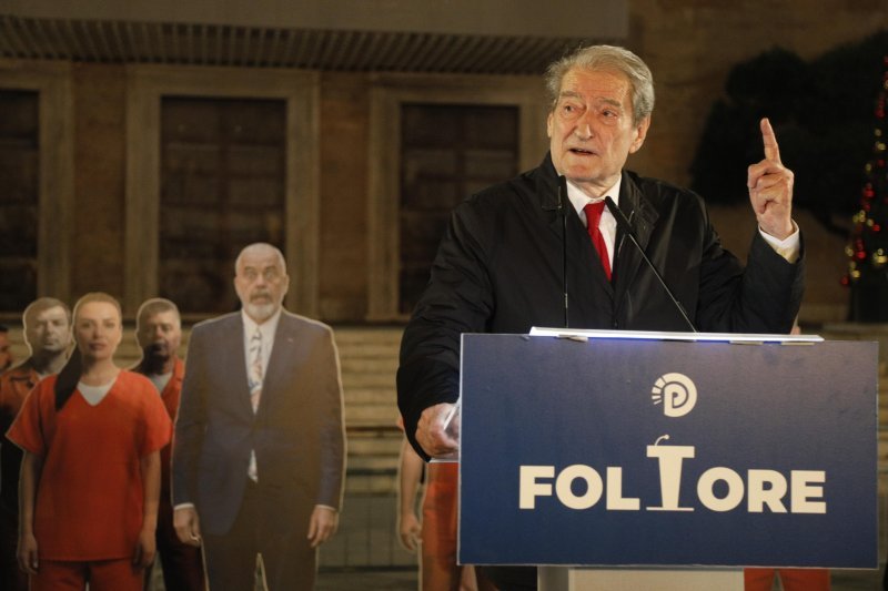 Лидер оппозиции Сали Бериша выступает за трибуной с баннером Демократической партии 'FOLTORE' во время предшествующего оппозиционного митинга в Тиране