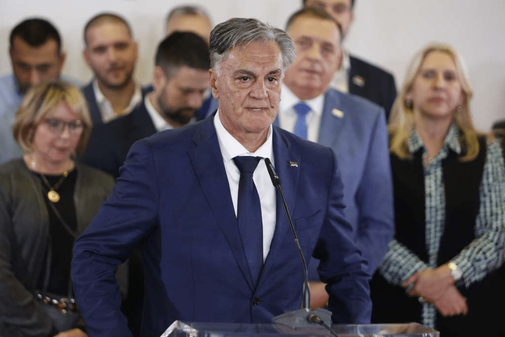 Синиша Каран выступает на трибуне в окружении сторонников после победы на президентских выборах РС