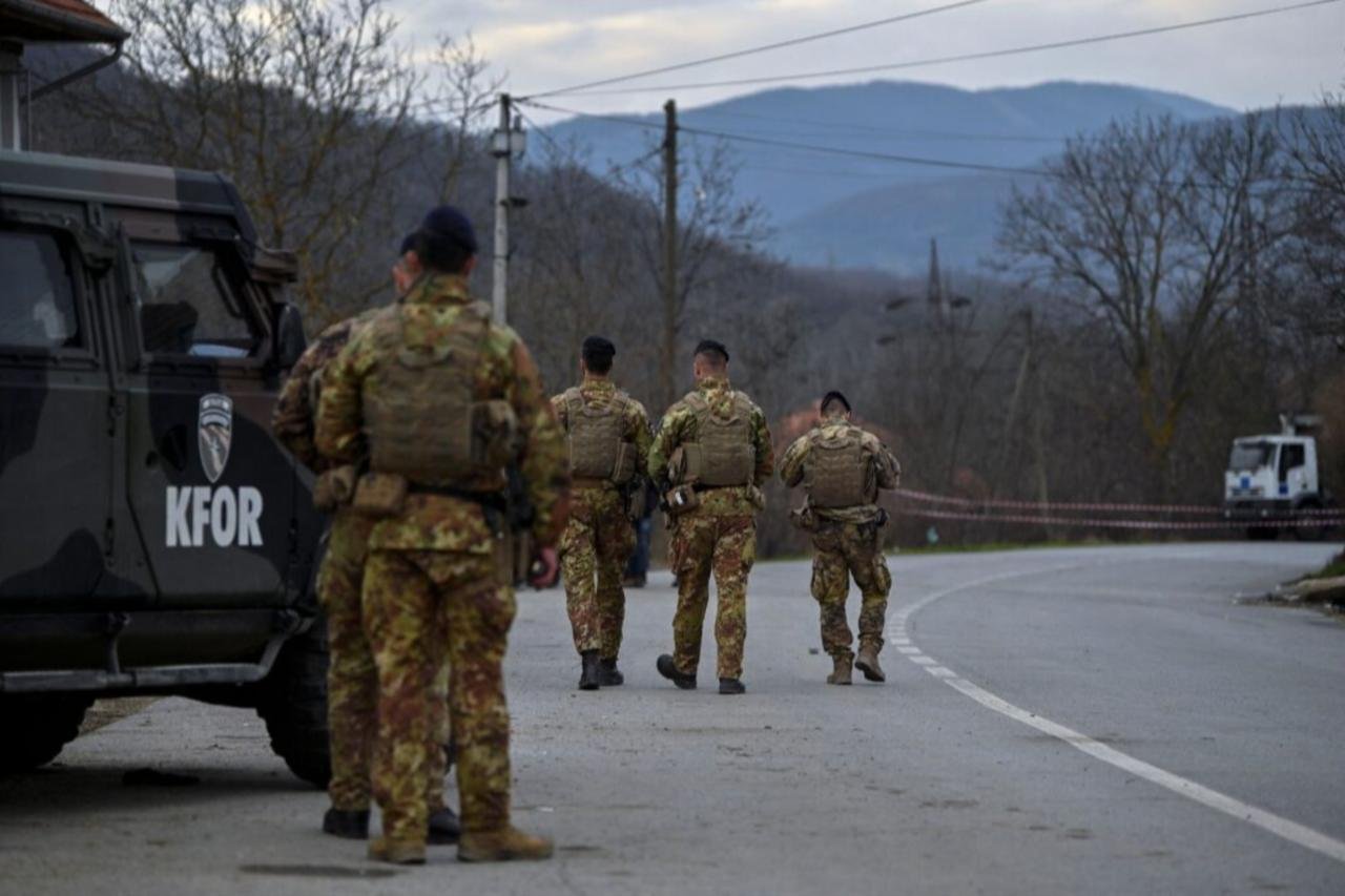 KFOR NATO peacekeeping soldiers patrolling road in Kosovo with military vehicle