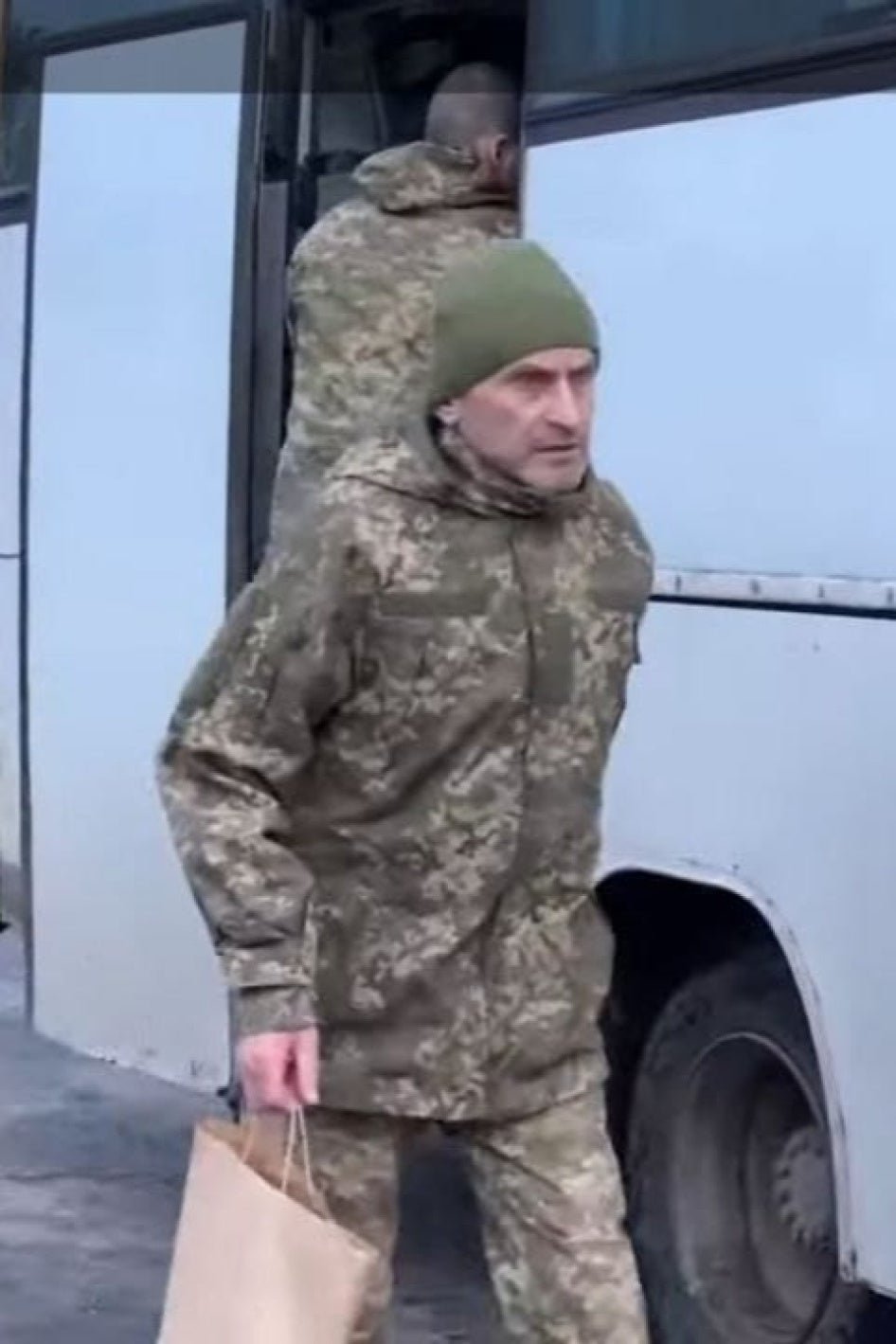 Released Ukrainian POW exiting exchange bus in military uniform