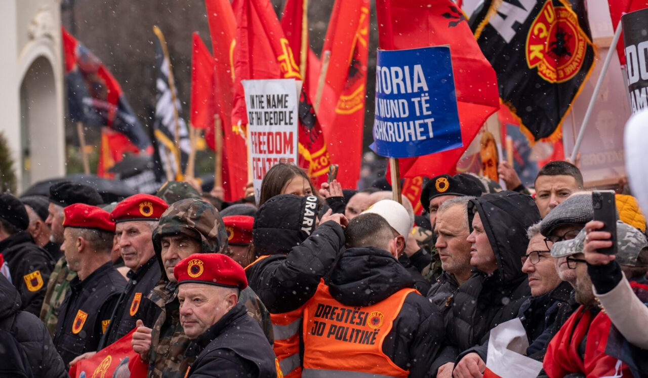 Ветераны АОК в красных беретах и оранжевых жилетах с надписью «Справедливость, а не политика» на протесте