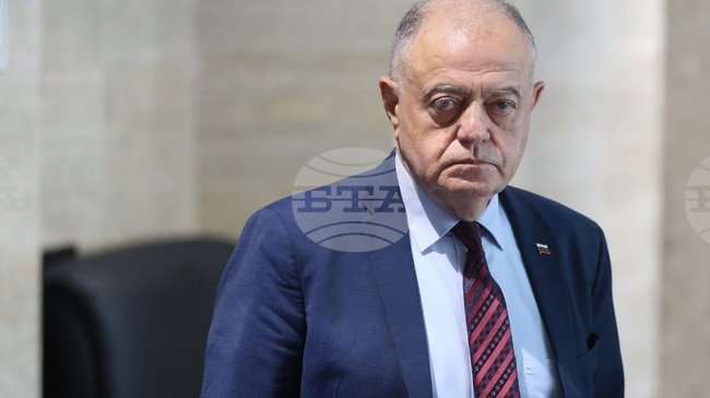 Senior politician in suit with Bulgarian flag pin, serious expression