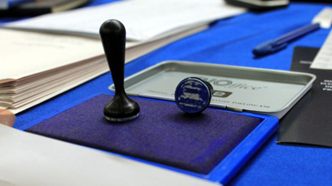 Избирательная печать и штемпельная подушка на голубом столе для голосования с документами