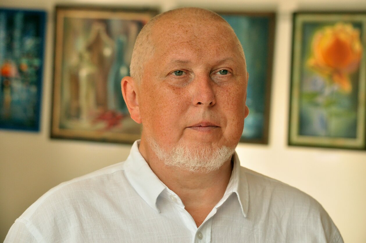 Портрет украинского историка в белой рубашке, на фоне картины