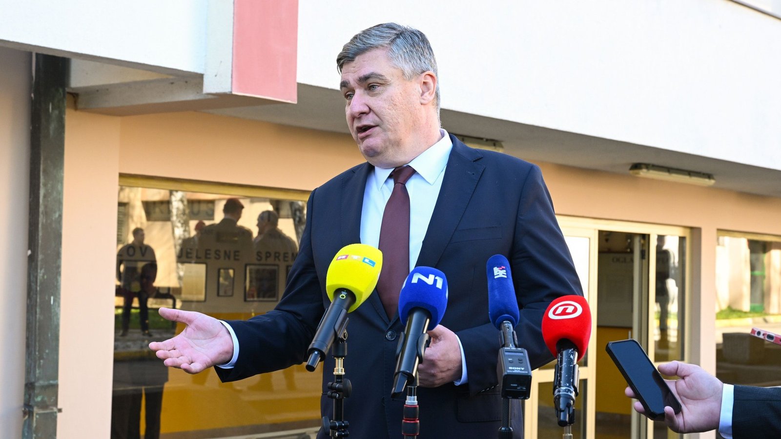 Президент Хорватии Зоран Миланович выступает на пресс-конференции перед микрофонами различных СМИ