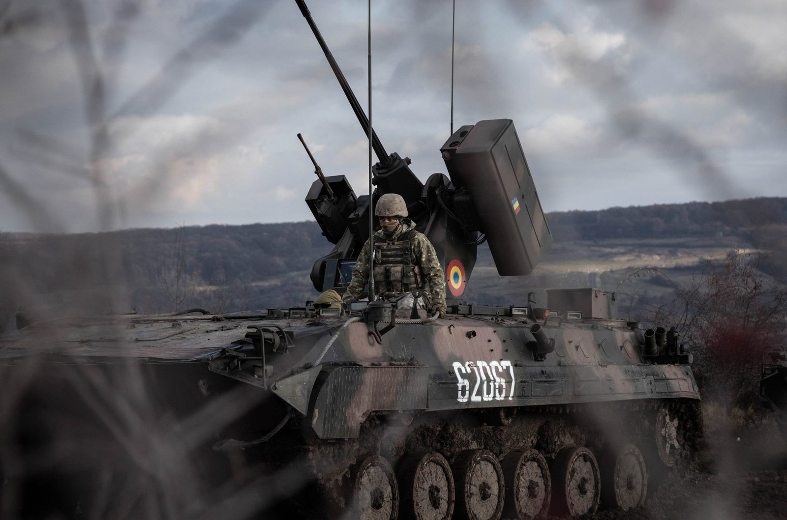 Румынский солдат на бронетранспортёре с военной символикой Румынии