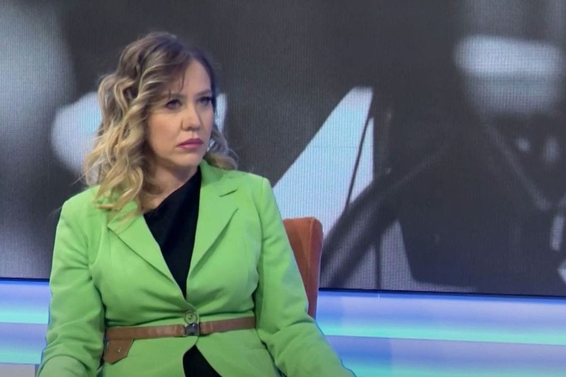 Woman in green jacket during TV studio interview