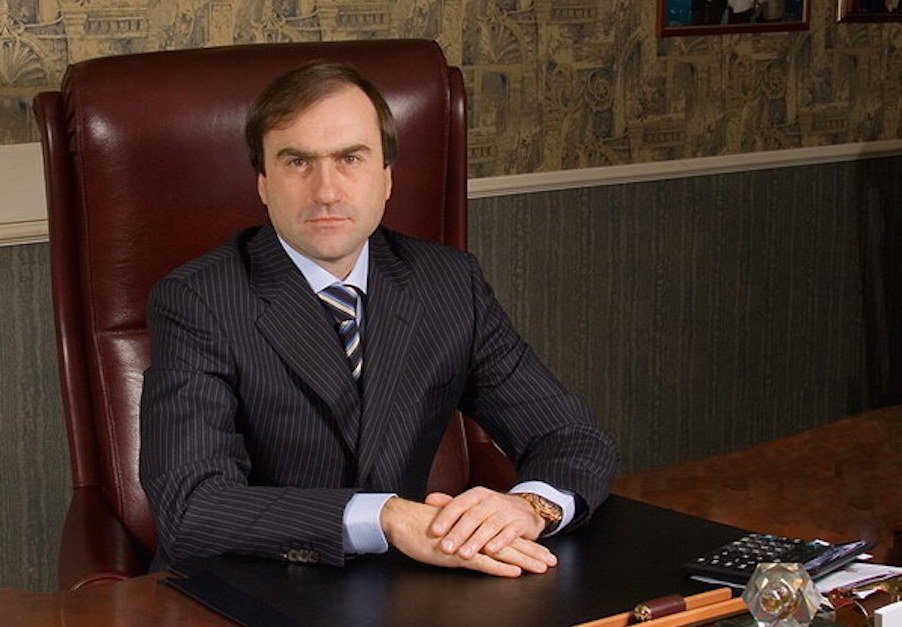 Виктор Гушан, сооснователь холдинга «Шериф», за рабочим столом в деловом костюме