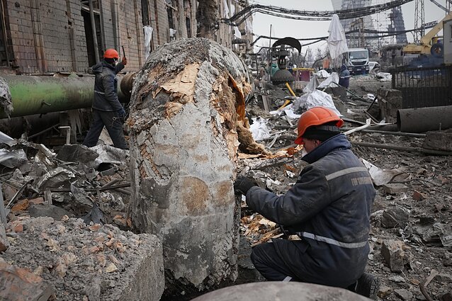 Рабочие разбирают завалы на месте разрушений в Украине