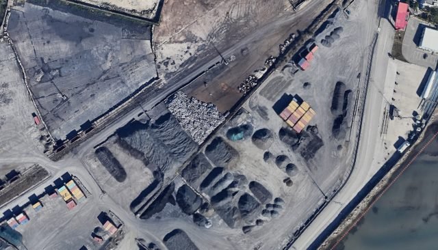 Вид с воздуха на площадку хранения промышленных отходов с контейнерами и кучами материалов