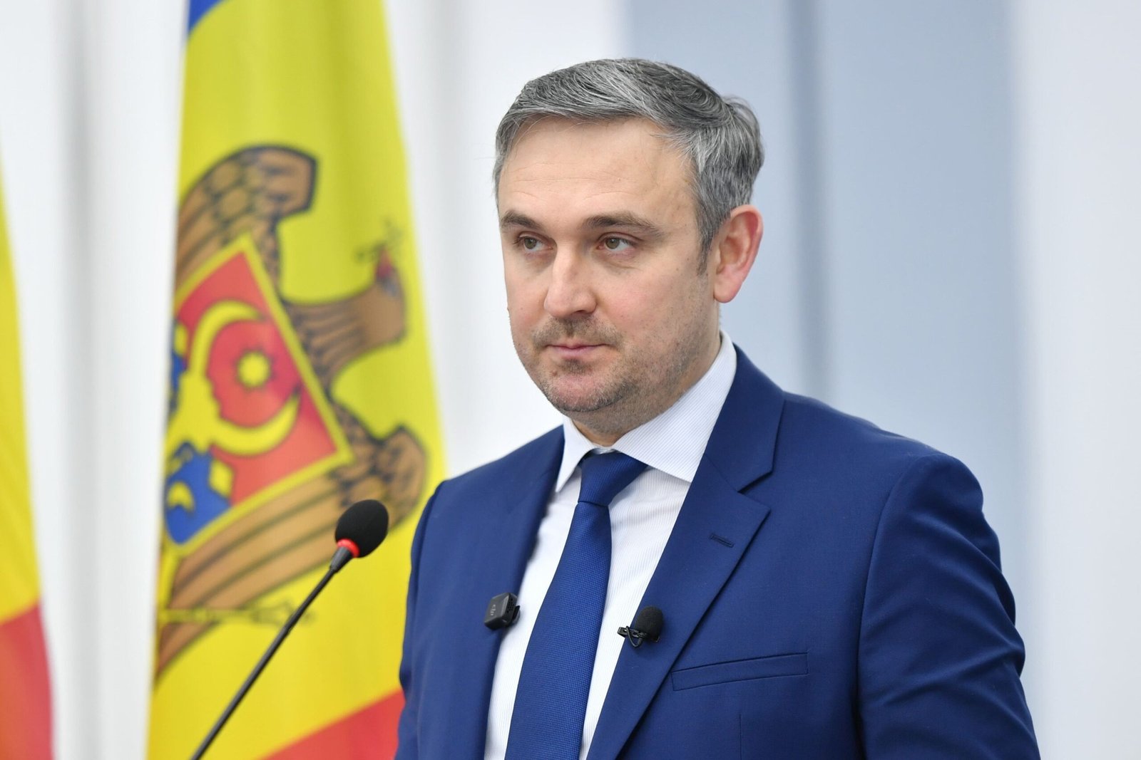 Minister of Culture Sergiu Jardan speaking at podium with Moldovan flag