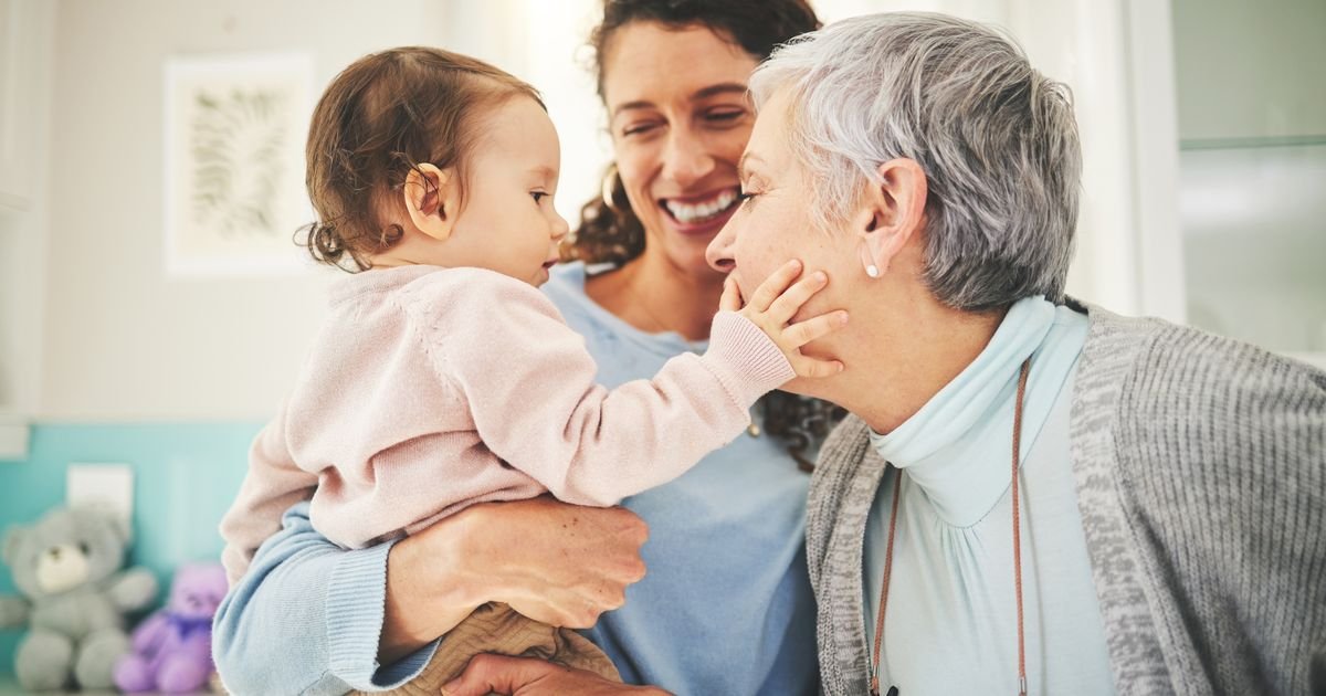 Три поколения женщин — бабушка, мама и малышка — в теплом семейном общении