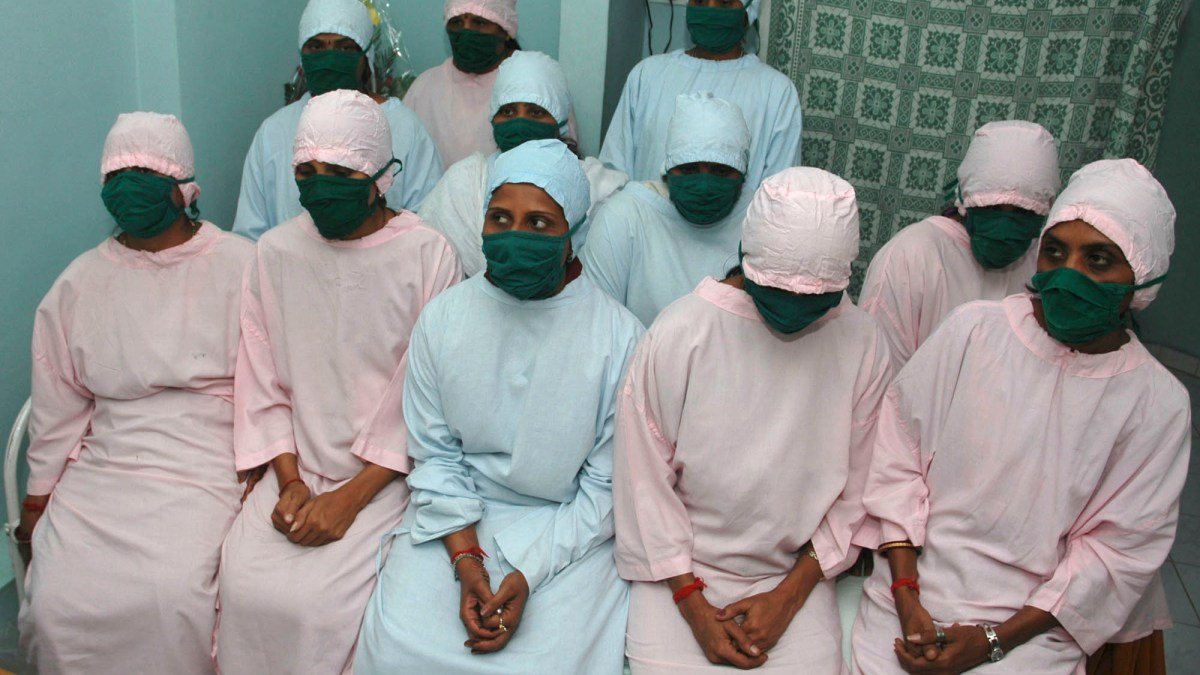 Суррогатные матери в медицинских халатах и масках в клинике в Индии