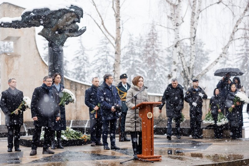 34 года войны на Днестре: Санду назвала Россию агрессором Президент Майя Санду выступает на трибуне во время церемонии в День памяти и благодарности, идёт снег, на заднем плане виден мемориал. Фото: Unknown