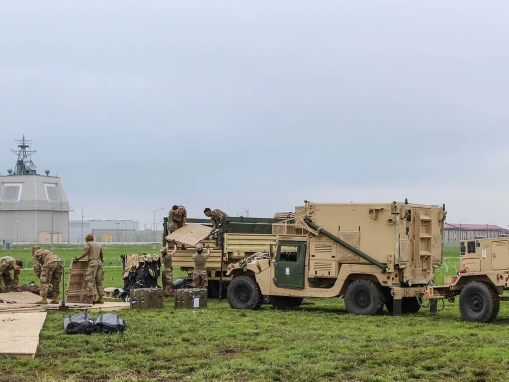 Американские военнослужащие разгружают оборудование на базе Девеселу на фоне здания комплекса Aegis Ashore. Фото: Newsweek Romania