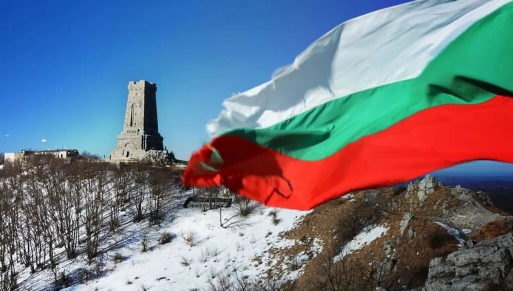 Памятник Свободы на перевале Шипка с развевающимся болгарским флагом на фоне зимнего горного пейзажа. Фото: Фактор